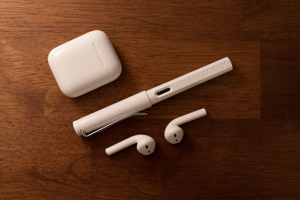 Apple AirPods and Lamy Safari fountain pen on a desk