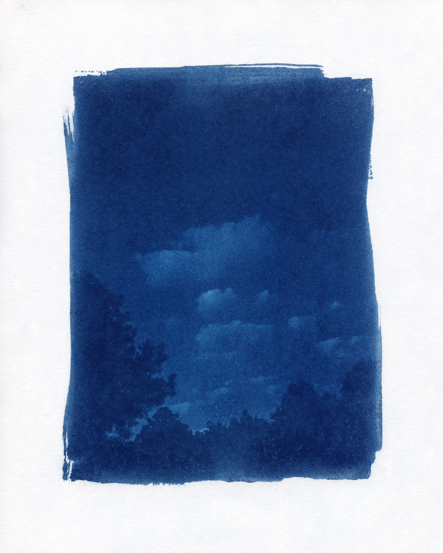 Cyanotype photograph showing clouds in a dark blue sky with the outline of trees below.